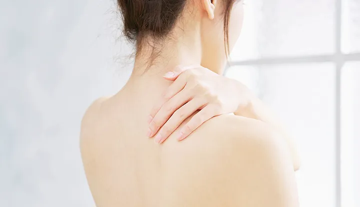 背中を触る女性